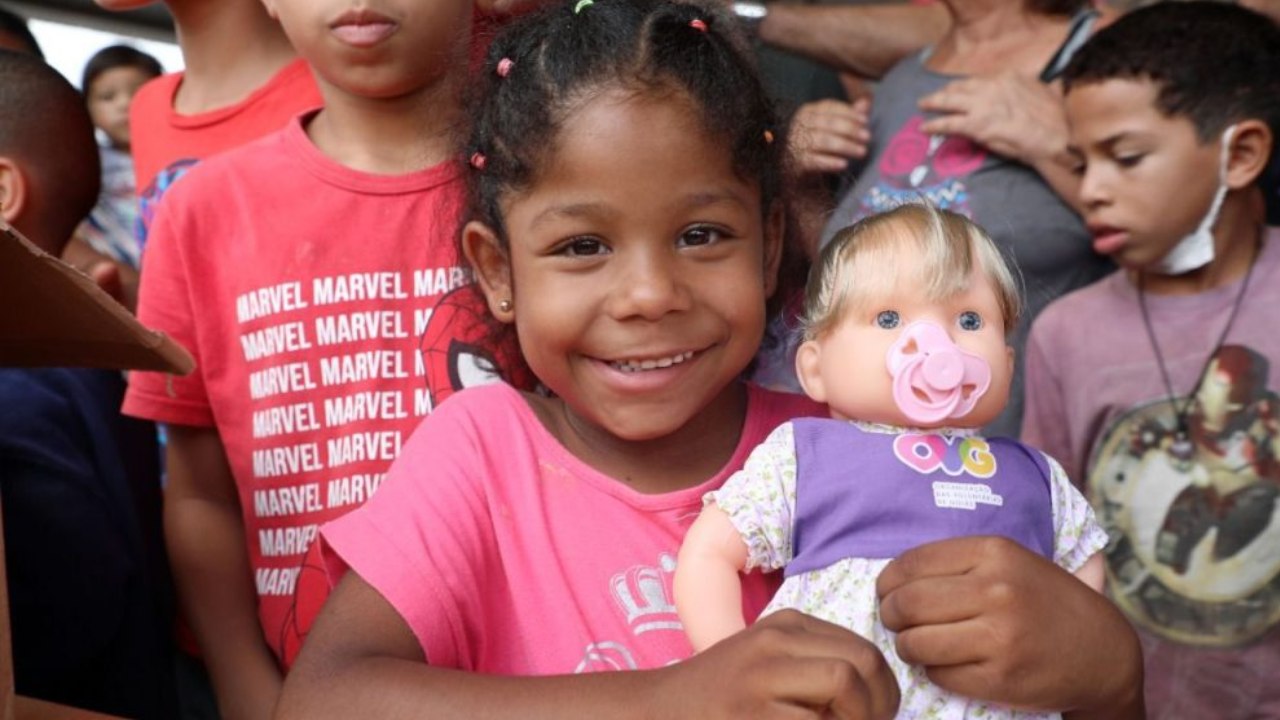 Criança com boneca recebida na ação